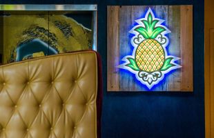 Pineapple logo sign on hotel lobby wall