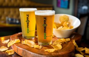 Pint glasses with draft beer and potato chips