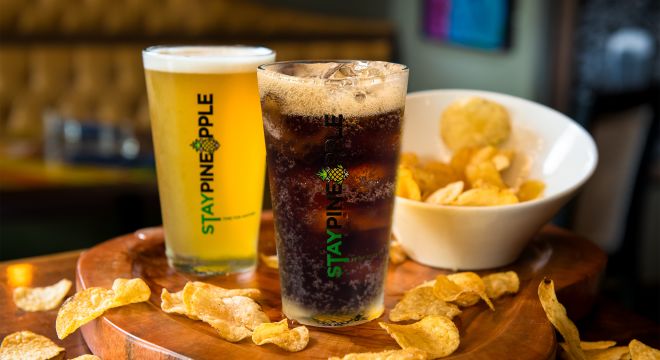 A soft drink, beer and chips on a table