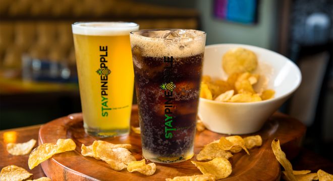 A soft drink, beer and chips on a table