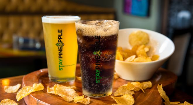 A soft drink, beer and chips on a table