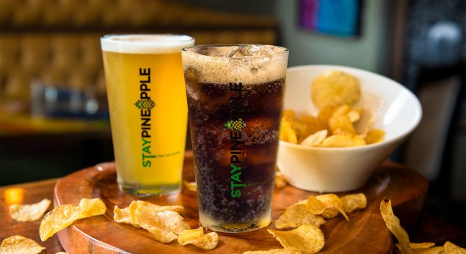 A soft drink, beer and chips on a table