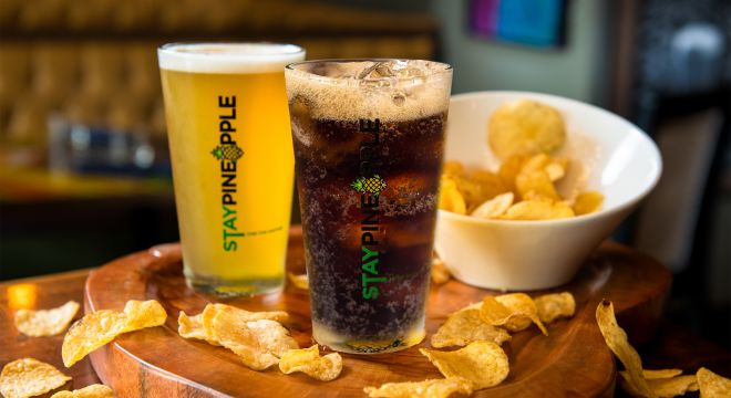 A soft drink, beer and chips on a table