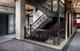 View of hotel hallway with staircase and elevator landing