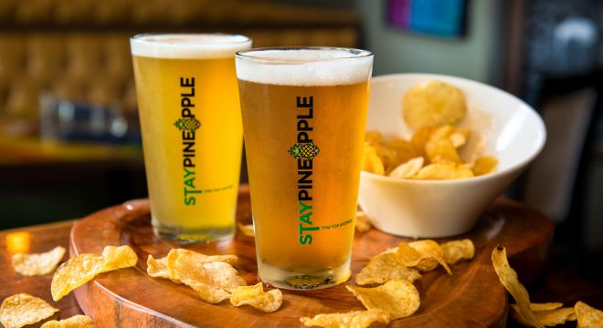 Pint glasses with draft beer and potato chips